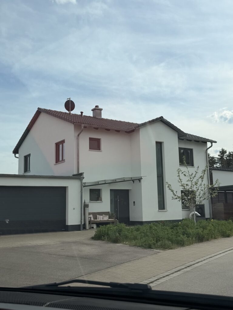 Weißes Satteldachhaus mit dunkler Garage
